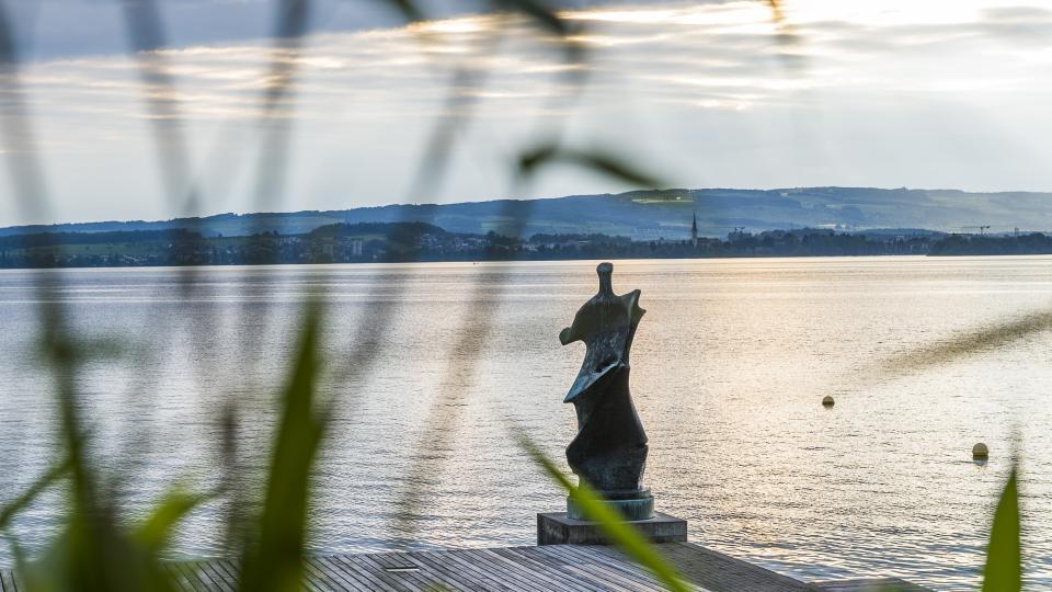 Die Statue von Henry Moore steht vor dem Zugersee in abendlicher Stimmung